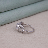 Silver ring with gemstones on a textured surface