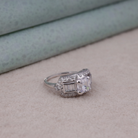 Silver ring with a large diamond on a light brown surface
