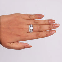 Hand wearing a diamond ring on a light gray background