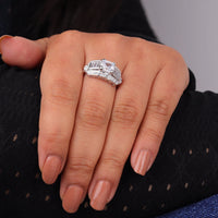Close-up of a hand wearing a diamond ring on a neutral background