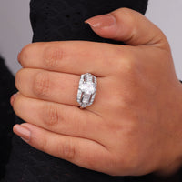 Close-up of a hand wearing a diamond ring with a blurred background