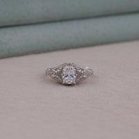 Silver ring with a diamond on a light gray surface