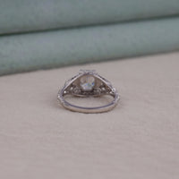 Silver ring with a diamond on a beige surface