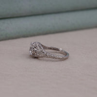 Silver ring with intricate design on a beige surface