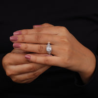 Hand wearing a diamond ring with a black background