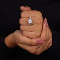 Hand holding a diamond ring against a black background
