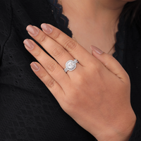 Hand wearing a silver ring with a black background, ushion Cut Moissanite Engagement Ring, Moissanite Guard Band Wedding Set, Halo Moissanite Bridal Jewelry, Cushion Moissanite Ring With Enhancer