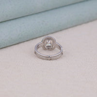 Silver ring with a diamond on a light beige surface, Modern Cushion Halo Engagement Ring, Durable Bridal Ring Guard With Cushion Stone, Vintage Inspired Halo Moissanite Bridal Jewelry