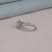 Silver ring with a diamond on a beige surface, Gorgeous Double Halo Bridal Jewelry, Elegant Moissanite Ring With Cushion Center.
