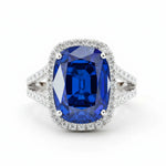 Ring with a blue gemstone and diamond-studded band on a white background