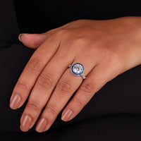 Close-up of a hand wearing a diamond ring with a dark background, Blue Sapphire Halo Ring – Round CZ Art Deco Vintage Target Design