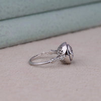 Silver ring with a diamond on a light background, Elegant Round CZ Blue Sapphire Ring – Vintage Art Deco Halo Target Jewelry