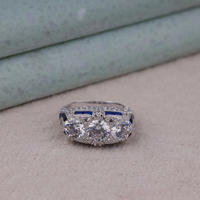 Diamond ring with blue gemstones on a neutral background