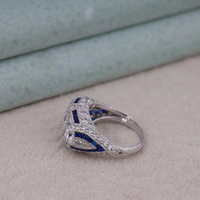 Silver ring with blue accents on a textured surface