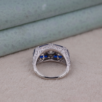 Silver ring with blue stones on a beige surface