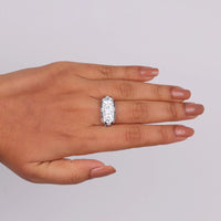 Diamond ring on a hand against a plain background