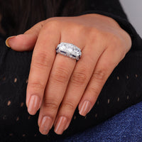 Close-up of a hand wearing a diamond ring with a blurred background
