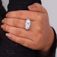 Hand wearing a diamond ring with a blurred background