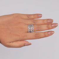 Hand wearing a silver ring on a plain background, Stylish Everyday Moissanite Wedding Band, Contemporary Crisscross Moissanite Jewelry, Durable Round Cut Moissanite Anniversary Ring