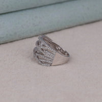 Silver ring with intricate design on a light beige surface, Criss Cross Party Wear Band With Round Moissanite, Round Cut Moissanite Party Ring, Crisscross Moissanite Wedding Band, Elegant Party Wear Moissanite Jewelry