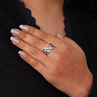 Hand wearing a silver ring with a black background, Bubble Bezel Set Round Moissanite Multi Layer Ring – Modern Wedding Band for Women