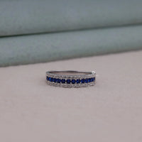 Silver ring with blue gemstones on a neutral background