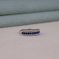 Silver ring with blue gemstones on a light gray background