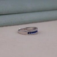 Silver ring with blue gemstones on a light gray background