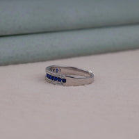 Silver ring with blue gemstones on a light gray background