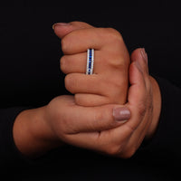 Close-up of two hands holding each other with a focus on a ring on one finger against a black background