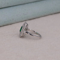 Silver ring with a green gemstone on a light gray surface, Symbolic Vintage Engagement Ring, Elegant Green CZ Bridal Fashion Ring, Classic Vintage Style Bridal Jewelry.