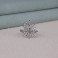 Silver star-shaped ring with clear stones on a light gray surface