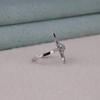 Silver ring with a diamond on a light gray surface