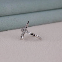 Silver ring with a diamond on a light gray surface