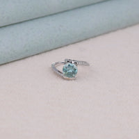 Silver ring with a blue gemstone on a light background