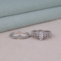 Two silver rings on a light surface with a neutral background, Art Deco Marquise and Round Moissanite Bridal Ring Set – Vintage Milgrain Design