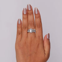 Hand wearing a silver ring with a diamond on a plain background, Marquise & Round Moissanite Art Deco Bridal Set – Vintage Milgrain Wedding Rings