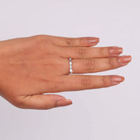 Hand wearing a diamond ring on a light gray background, Lab Created Moissanite Eternity Band, Modern Dot Dash Bridal Band, Moissanite Stacking Eternity Ring