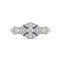 Art Deco vintage brooch featuring a round Cubic Zirconia center stone, blue accent stones, geometric design, and vintage-inspired styling.