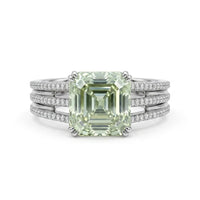 Asscher cut moissanite engagement ring with light green center stone, split shank pavé band, and elegant statement design