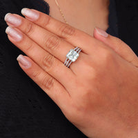 Asscher cut moissanite engagement ring with light green center stone, split shank pavé band, and elegant statement design