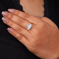 Cushion cut cubic zirconia three stone engagement ring with half moon side stones in a classic prong setting