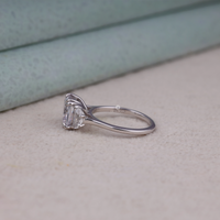 Cushion cut cubic zirconia three stone engagement ring with half moon side stones in a classic prong setting