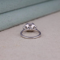 Cushion cut cubic zirconia three stone engagement ring with half moon side stones in a classic prong setting