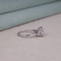 Cushion cut cubic zirconia three stone engagement ring with half moon side stones in a classic prong setting
