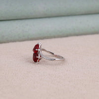 Heart cut Cubic Zirconia floral cluster ring featuring deep red center stones, clear marquise and pear accent stones, pavé band, elegant statement design.