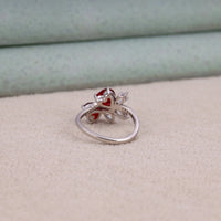 Heart cut Cubic Zirconia floral cluster ring featuring deep red center stones, clear marquise and pear accent stones, pavé band, elegant statement design.