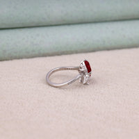 Heart cut Cubic Zirconia floral cluster ring featuring deep red center stones, clear marquise and pear accent stones, pavé band, elegant statement design.