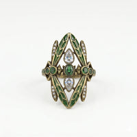 Decorative ring with green gemstones and gold accents on a white background