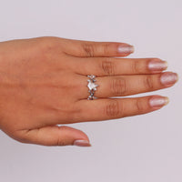 Nature-inspired vine ring featuring a kite cut cubic zirconia center stone with round accent stones and botanical leaf detailing